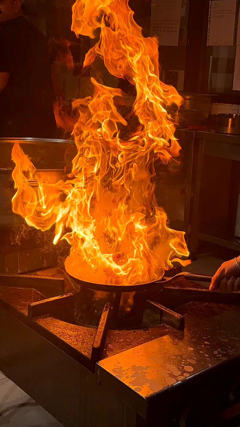 Profesyonel catering mutfağında alevde pişirilen yemek